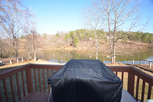 wooden deck featuring a water view and a grill