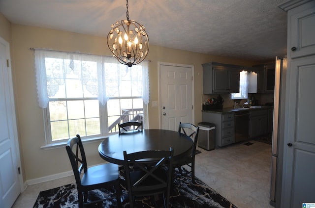 dining space featuring baseboards, a chandelier, and a textured ceiling