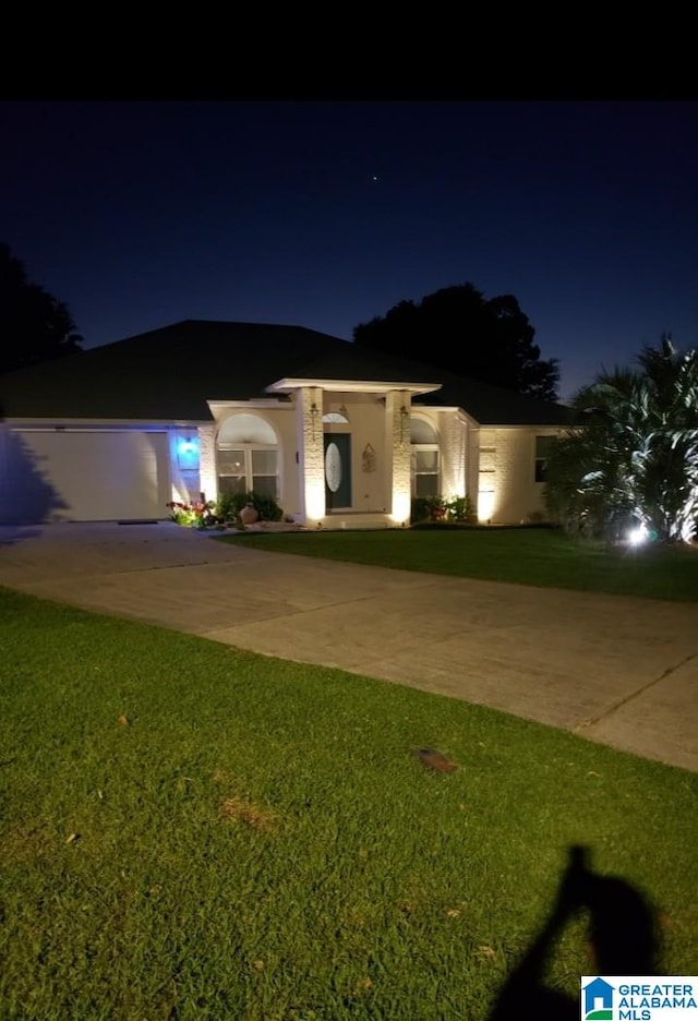 view of front facade with driveway and a yard