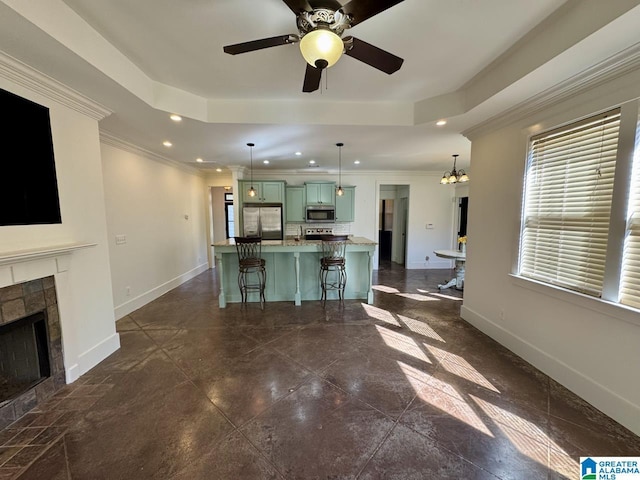 kitchen with stainless steel appliances, a raised ceiling, baseboards, and green cabinets