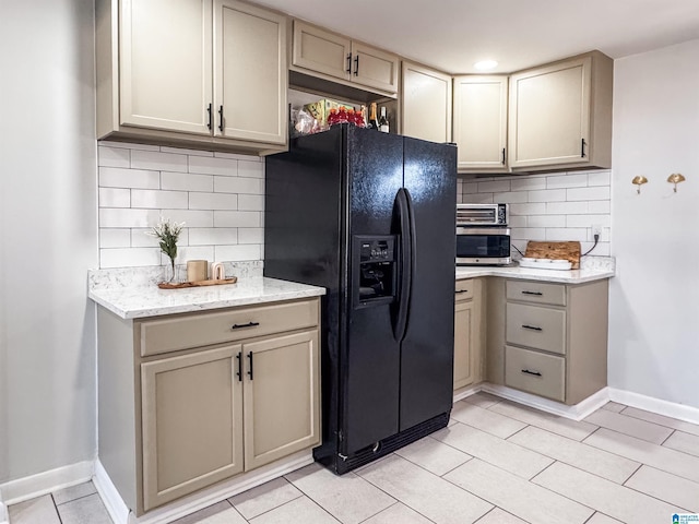 kitchen featuring tasteful backsplash, black refrigerator with ice dispenser, baseboards, and light tile patterned floors