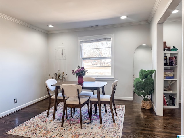 dining room featuring baseboards, visible vents, ornamental molding, and dark wood finished floors