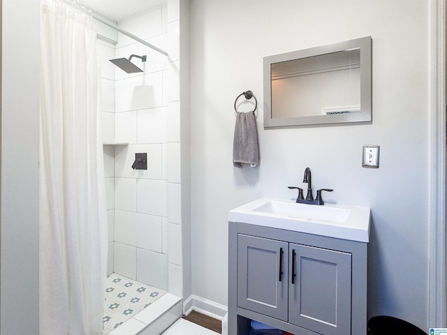 full bath featuring baseboards, a shower stall, and vanity