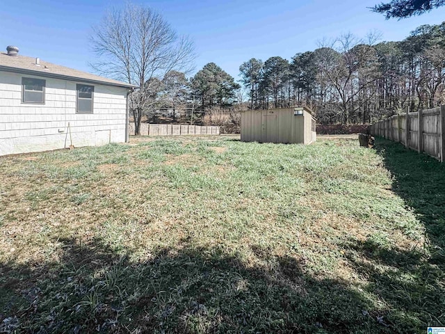 view of yard with an outbuilding, a shed, and fence