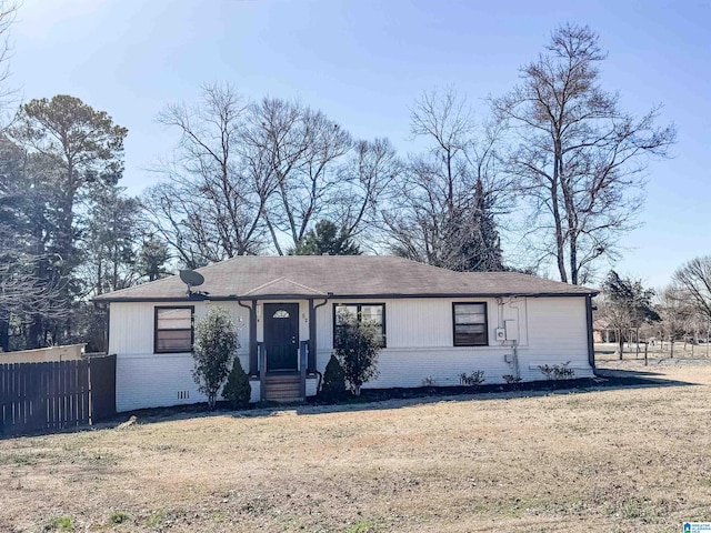 single story home with brick siding, fence, and a front lawn