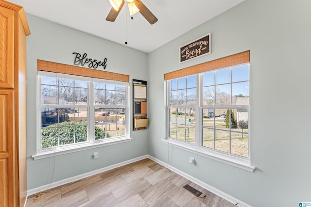 unfurnished room with a ceiling fan, baseboards, and visible vents