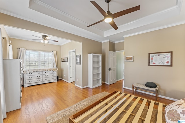 unfurnished bedroom with baseboards, a raised ceiling, light wood-style floors, and ornamental molding