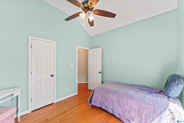 bedroom with wood finished floors, a ceiling fan, baseboards, and vaulted ceiling