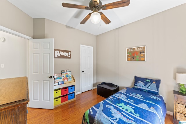 bedroom with baseboards, a ceiling fan, and wood finished floors