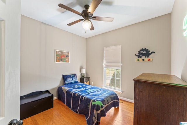 bedroom featuring ceiling fan, baseboards, and wood finished floors