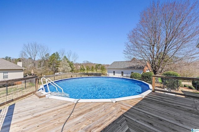 view of pool with a fenced in pool, a deck, and fence