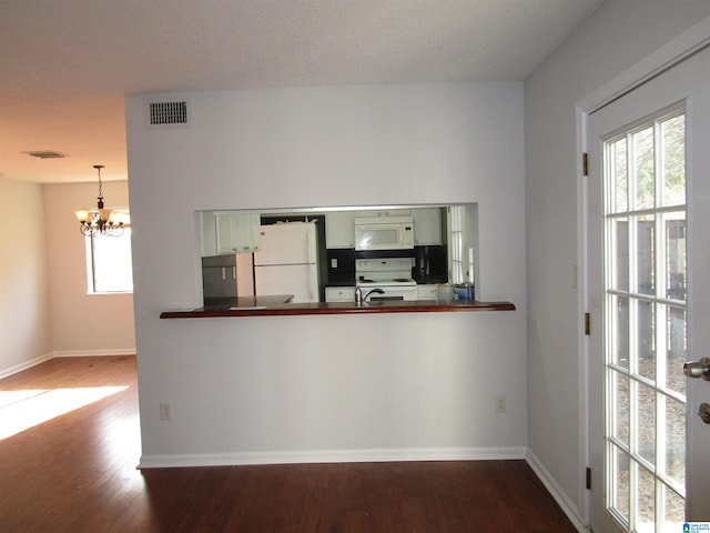 3830 Windhover Dr Unit 1, Vestavia Hills, AL 35216 - kitchen with dark countertops, an inviting chandelier, wood finished floors, white appliances, and baseboards