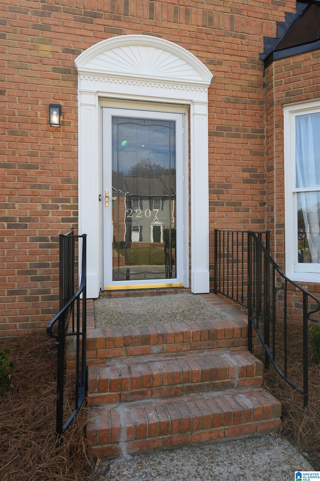 doorway to property featuring brick siding