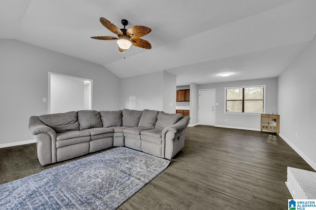 living room featuring baseboards, vaulted ceiling, and dark wood finished floors