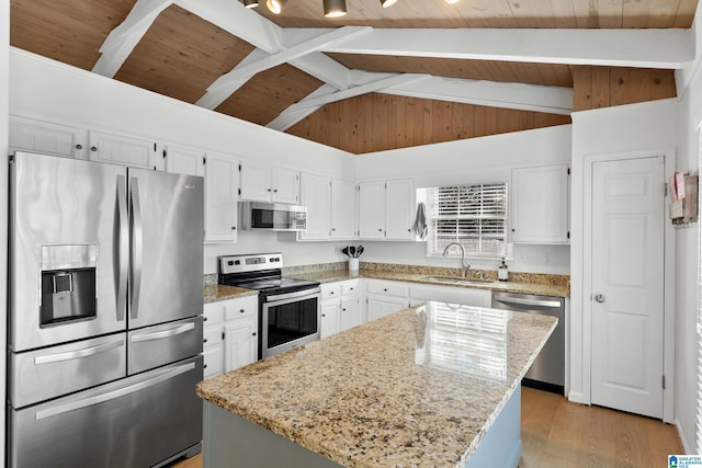 kitchen with stainless steel appliances, light wood-style floors, a sink, and light stone counters