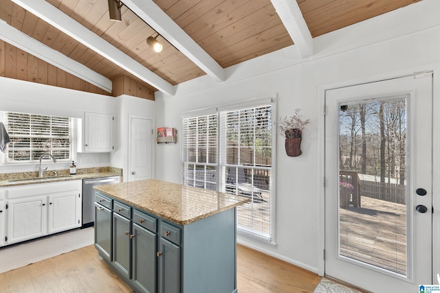 kitchen featuring light wood-type flooring, stainless steel dishwasher, white cabinets, and a sink