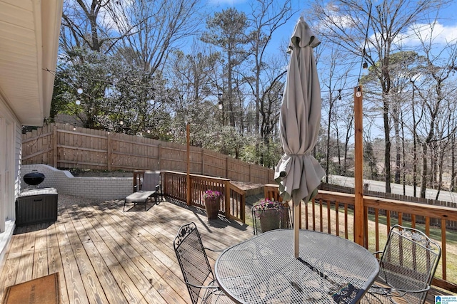 deck with a fenced backyard and outdoor dining space