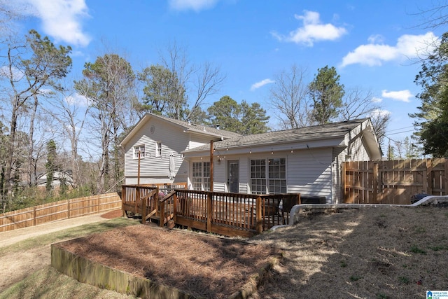 back of house with a deck and fence