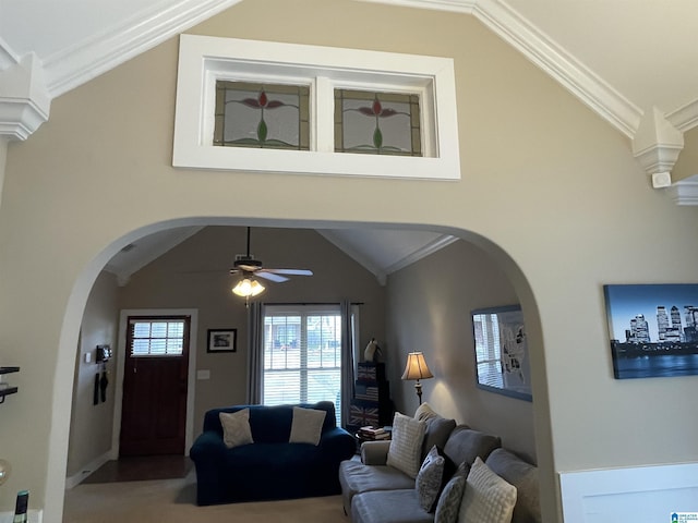 living area with ornamental molding, lofted ceiling, ceiling fan, and arched walkways