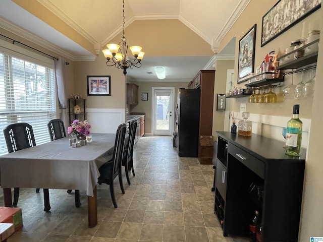 dining room featuring a bar, ornamental molding, vaulted ceiling, and a notable chandelier