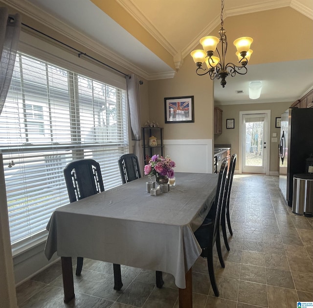 dining room featuring ornamental molding, vaulted ceiling, and an inviting chandelier