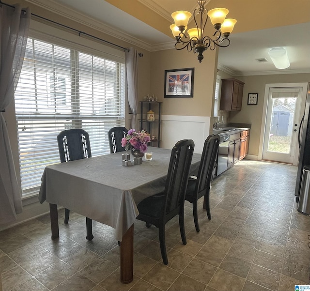 dining area featuring a chandelier and crown molding