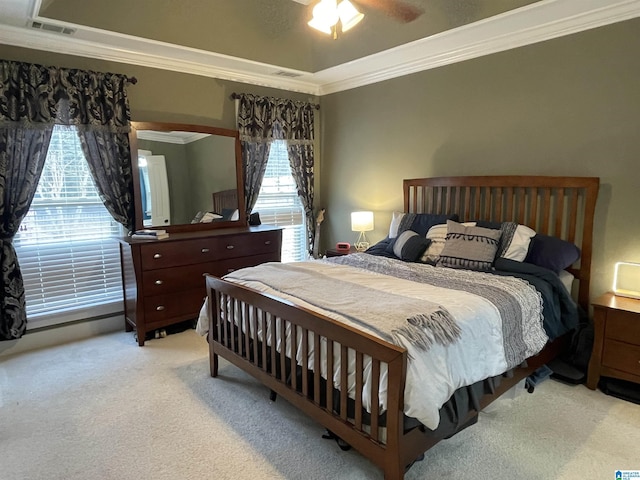 bedroom featuring ornamental molding, a ceiling fan, visible vents, and light colored carpet