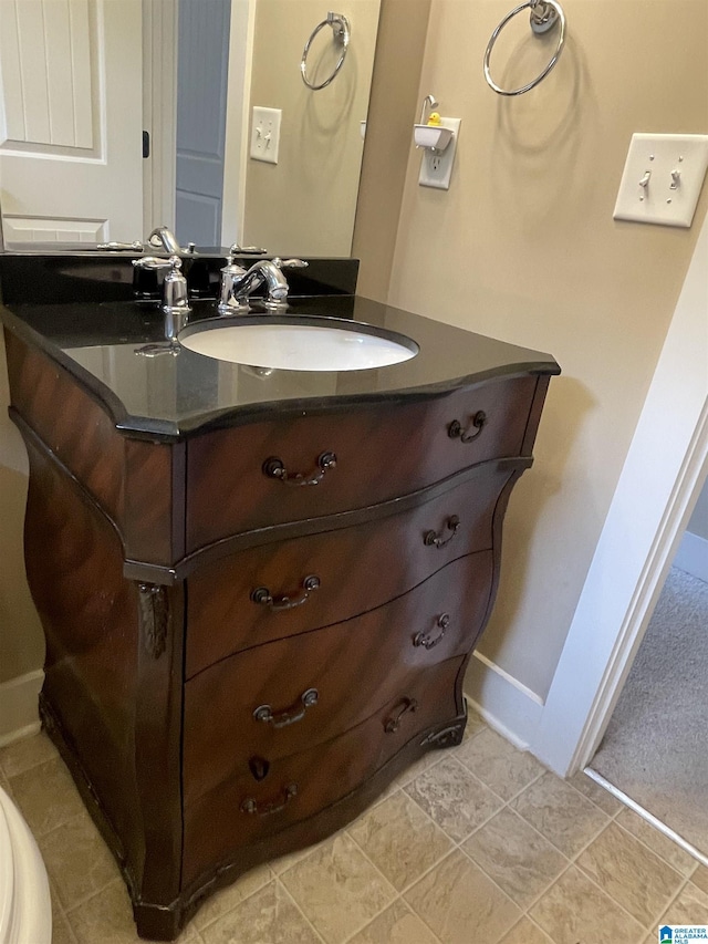 bathroom featuring tile patterned flooring, baseboards, and vanity