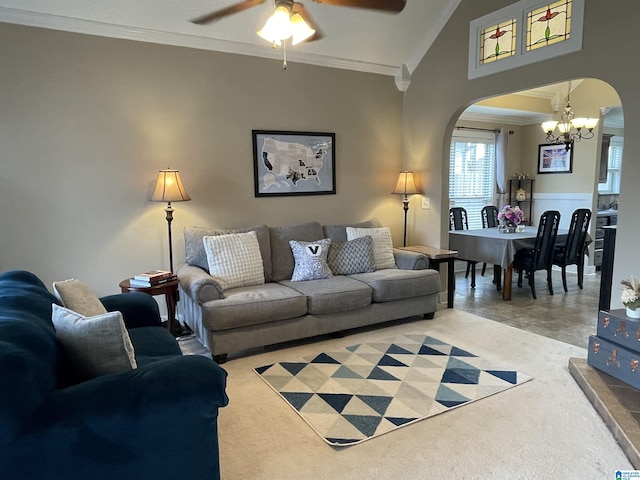 living room featuring ceiling fan with notable chandelier, arched walkways, vaulted ceiling, and ornamental molding