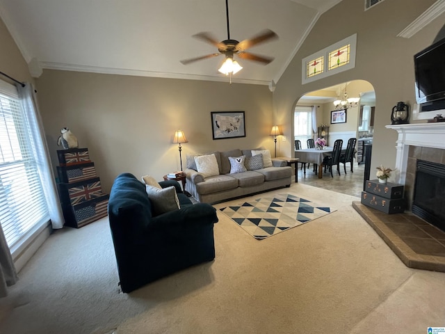 carpeted living area featuring ornamental molding, arched walkways, vaulted ceiling, and a tiled fireplace