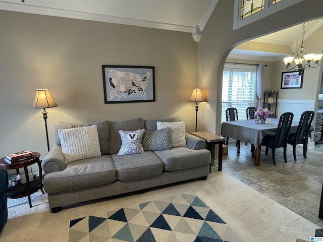 living room with an inviting chandelier, carpet, arched walkways, and ornamental molding