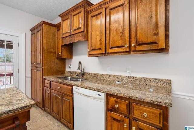 kitchen with a sink, a textured ceiling, light stone counters, and dishwasher