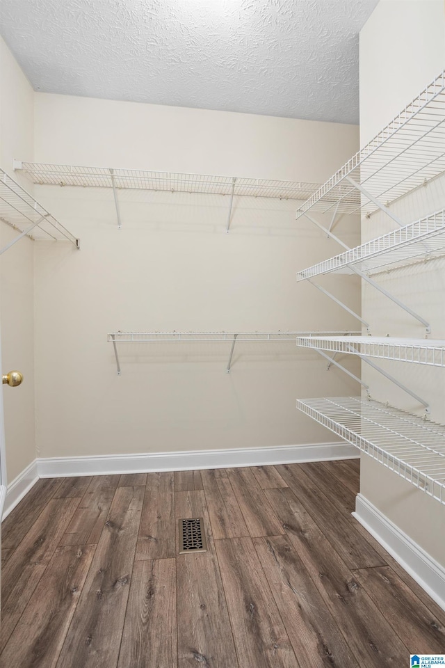 walk in closet with visible vents and wood finished floors