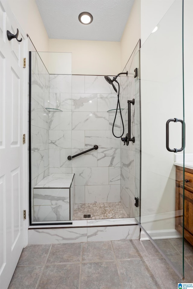 full bath featuring a shower stall, baseboards, and vanity