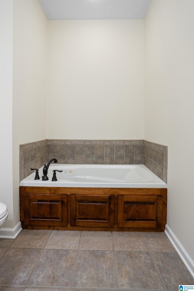 full bathroom with baseboards, a garden tub, and toilet