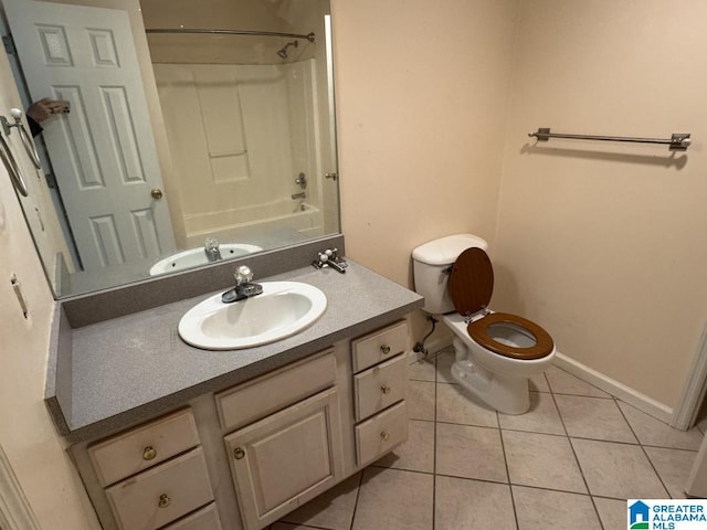 full bath with shower / bath combination, toilet, vanity, tile patterned flooring, and baseboards