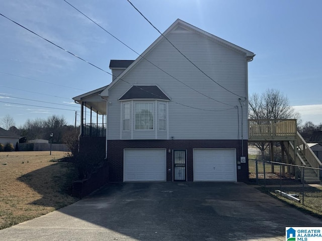 view of side of property featuring stairs, aphalt driveway, and an attached garage