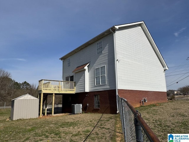 back of house with a storage unit, a deck, cooling unit, a yard, and an outdoor structure