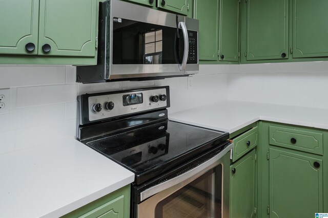 kitchen featuring appliances with stainless steel finishes, light countertops, and green cabinetry