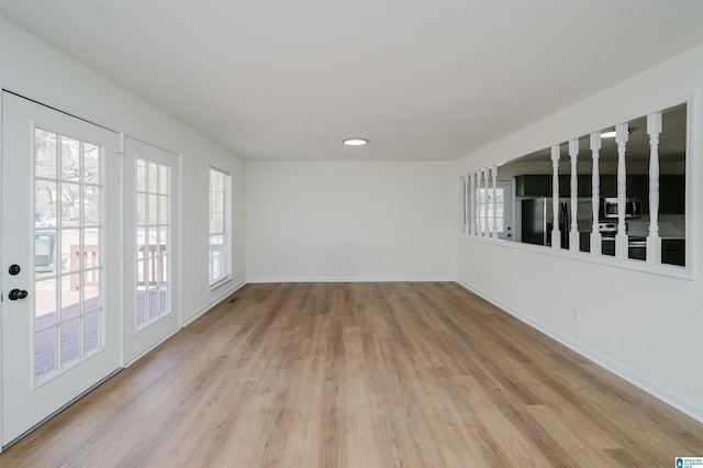 unfurnished room featuring light wood finished floors and baseboards