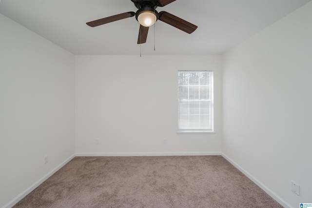 empty room featuring carpet, baseboards, and ceiling fan