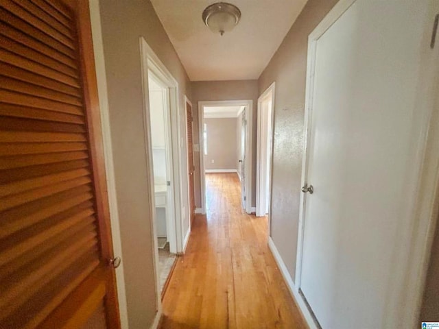 hallway with light wood-style flooring and baseboards