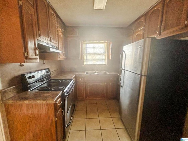 kitchen featuring light tile patterned floors, under cabinet range hood, a sink, appliances with stainless steel finishes, and brown cabinets