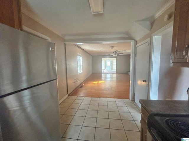 corridor with crown molding and light tile patterned flooring