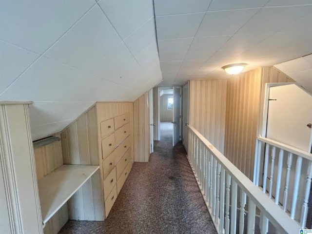 bonus room featuring carpet floors, wood walls, and vaulted ceiling