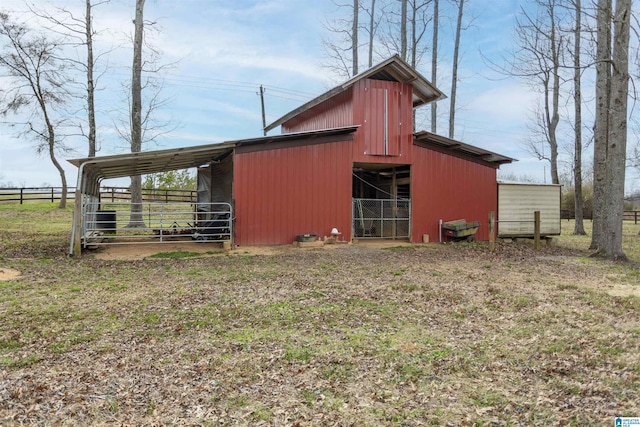 view of outbuilding featuring an outbuilding, a carport, and fence