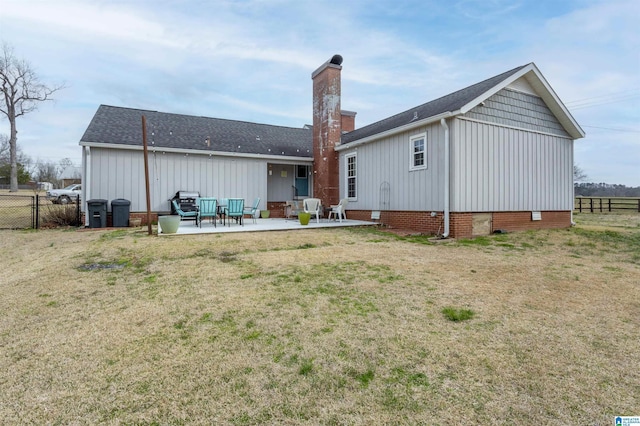 back of property with a yard, a patio, a chimney, crawl space, and fence