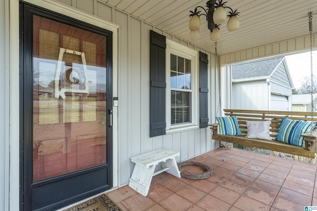 doorway to property featuring a ceiling fan, a porch, and board and batten siding