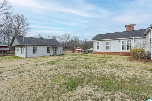 view of yard featuring entry steps, french doors, and fence