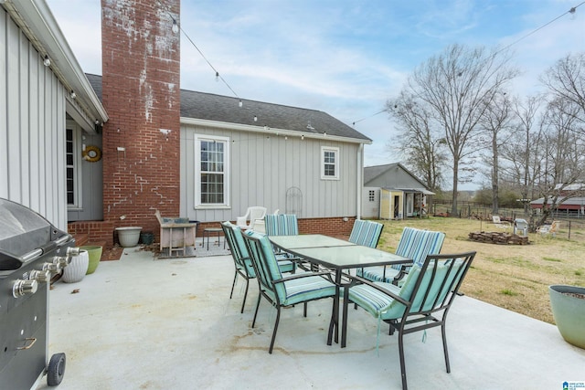 view of patio with a grill, fence, and outdoor dining space